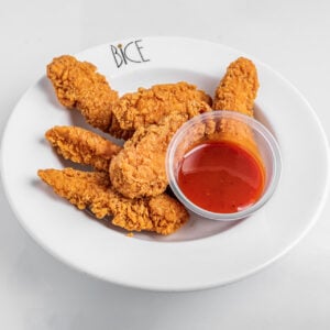 Lani&egrave;res de poulet croustillantes servies avec sauce BBQ Signature, sp&eacute;cialit&eacute; Italian bice cuisine.
