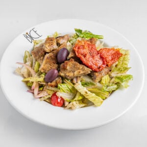 Salade de veau avec laitue romaine, tomates cerises, oignons rouges, concombres, olives et sauce maison