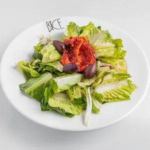 House salad with romaine lettuce, cherry tomatoes, cucumber, and red onion with signature dressing