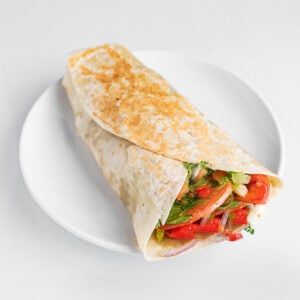 Wrap v&eacute;g&eacute;tarien &agrave; la tortilla, provolone, poivrons r&ocirc;tis, oignons caram&eacute;lis&eacute;s, aubergines, laitue et tomate