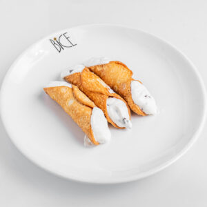 Mini cannoli filled with sweet ricotta and chocolate chips in crunchy shells, Italian cuisine dessert