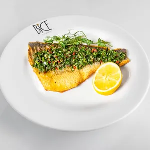 Bar m&eacute;diterran&eacute;en po&ecirc;l&eacute; garni d&rsquo;herbes fra&icirc;ches, de tomates et de citron