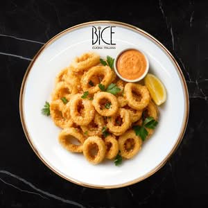 Golden Calamari Fritti rings with crispy batter and spicy mayo, an Italian cuisine appetizer