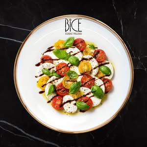 Caprese di fior di latte with cherry tomatoes, basil, olive oil, and balsamic glaze for fresh Italian cuisine