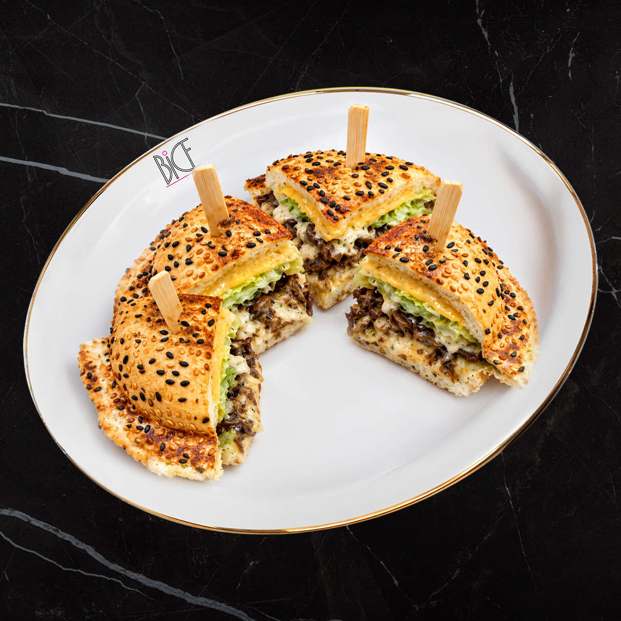 Steak Bomb panino with cheddar Italian-inspired Steak Bomb panino cut in four, filled with steak, cheddar, caramelized onions and mushrooms