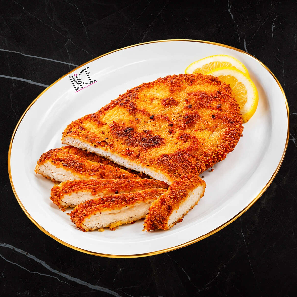 Chicken Milanese with lemon Golden Chicken Milanese cutlets with lemon wedge, a classic Italian cuisine dish