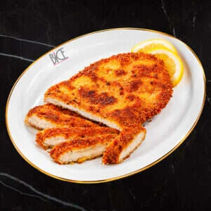 Escalope de poulet Milanaise panée et dorée, servie avec quartier de citron, hommage à la cuisine italienne