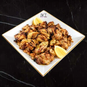 Piri-Piri grilled chicken Piri-Piri grilled chicken thighs topped with mild sauce and fresh garnish on a serving platter