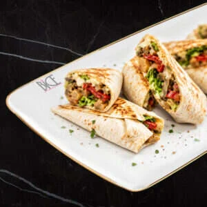 Italian cuisine veggie mini wraps with melted cheeses, eggplant, roasted peppers, lettuce and tomato