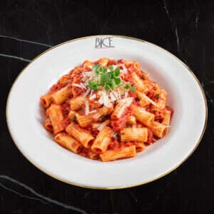 Pâtes ’Nduja Pomodoro épicées avec sauce tomate-basilic, oignons rouges et parmesan, cuisine italienne